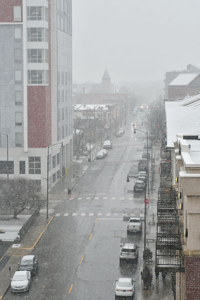 Fog fades away as snow falls on Tenth Street
